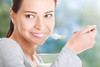 Healthy woman eating yoghurt.