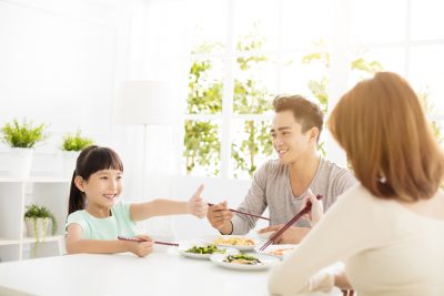 daughter gives mother  thumbs up for the delicious dinner